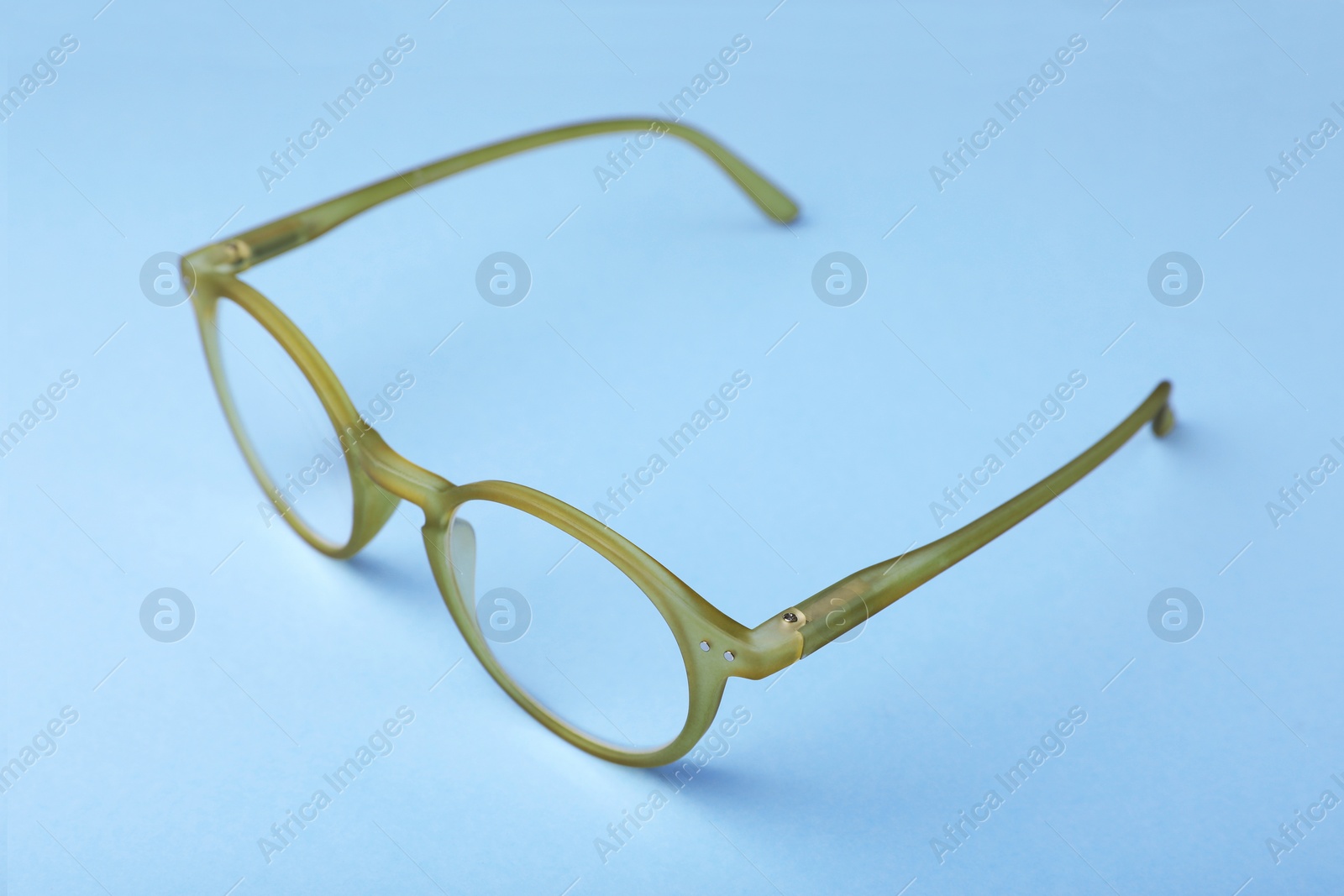 Photo of Glasses with corrective lenses on light blue background