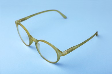 Photo of Glasses with corrective lenses on light blue background