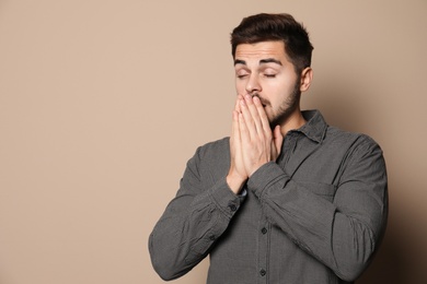 Photo of Handsome young man coughing against color background. Space for text