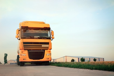 Photo of Modern yellow truck on country road. Space for text