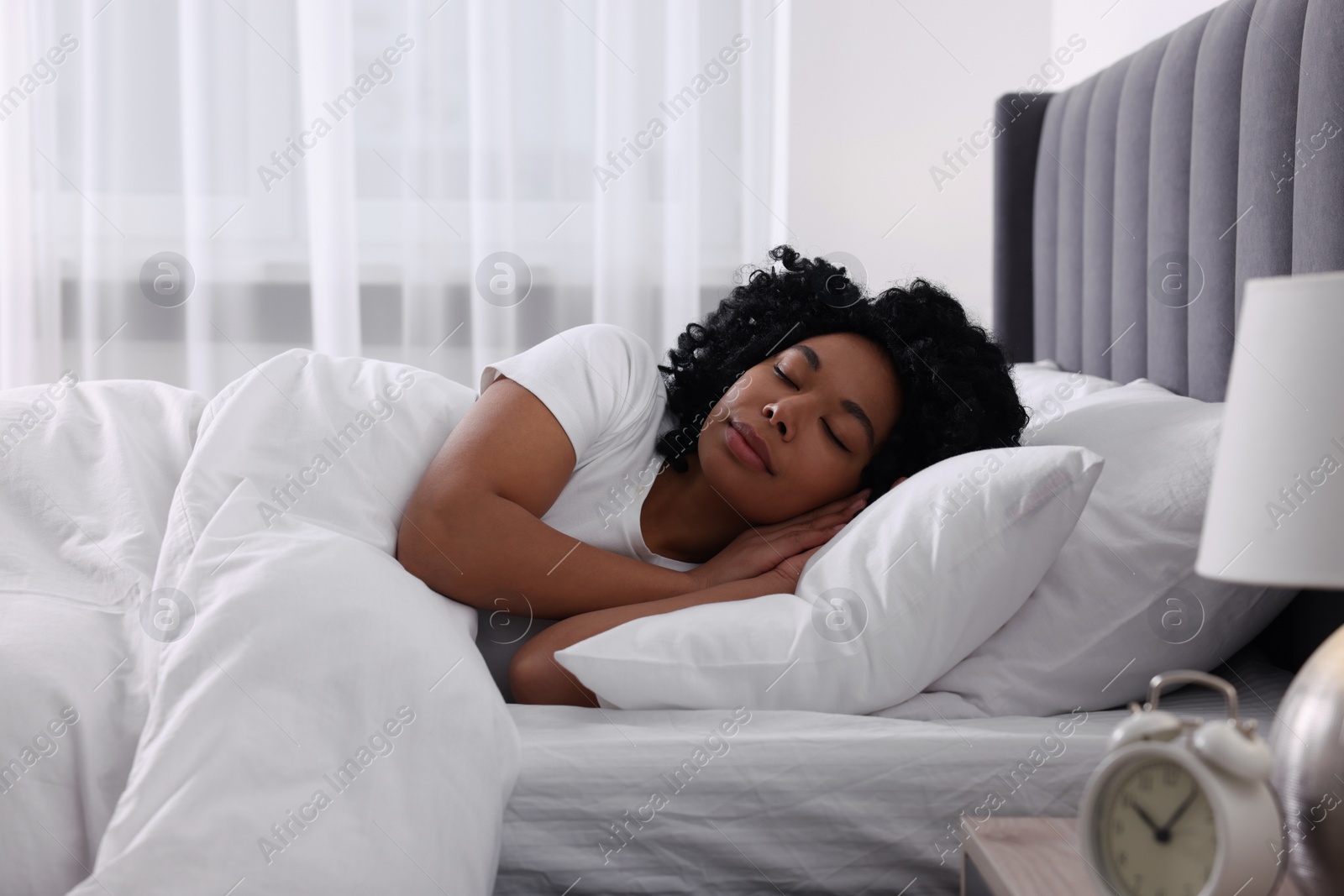 Photo of Beautiful young woman sleeping in soft bed at home