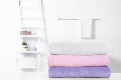 Stack of fresh towels on table in bathroom. Space for text