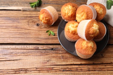 Photo of Delicious sweet muffins on wooden table, flat lay. Space for text