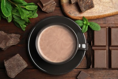Photo of Cup of delicious hot cocoa, chocolate chunks and fresh mint on wooden table, flat lay