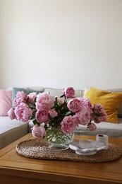 Beautiful pink peonies in vase on table at home, space for text. Interior design