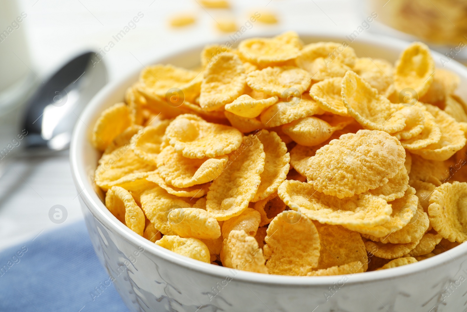 Photo of Tasty corn flakes on white table, closeup