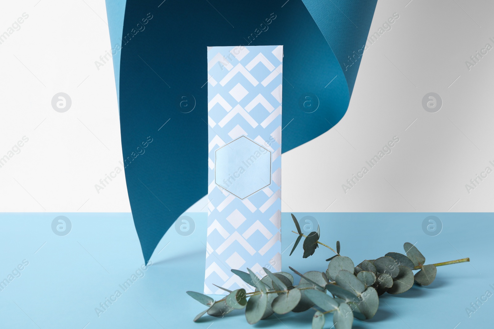 Photo of Scented sachet and eucalyptus branches on color background