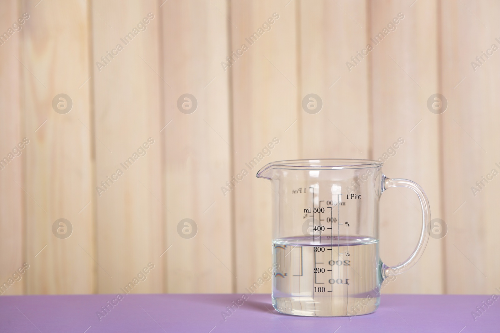 Photo of Measuring cup with vinegar on table. Space for text