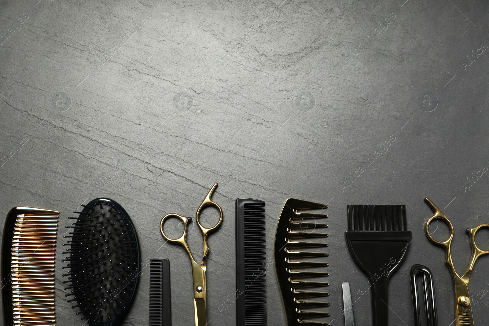 Photo of Hairdressing tools on grey textured background, flat lay. Space for text