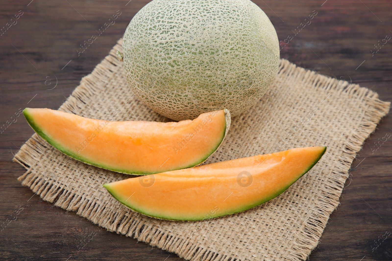 Photo of Cut and whole delicious ripe melons on wooden table