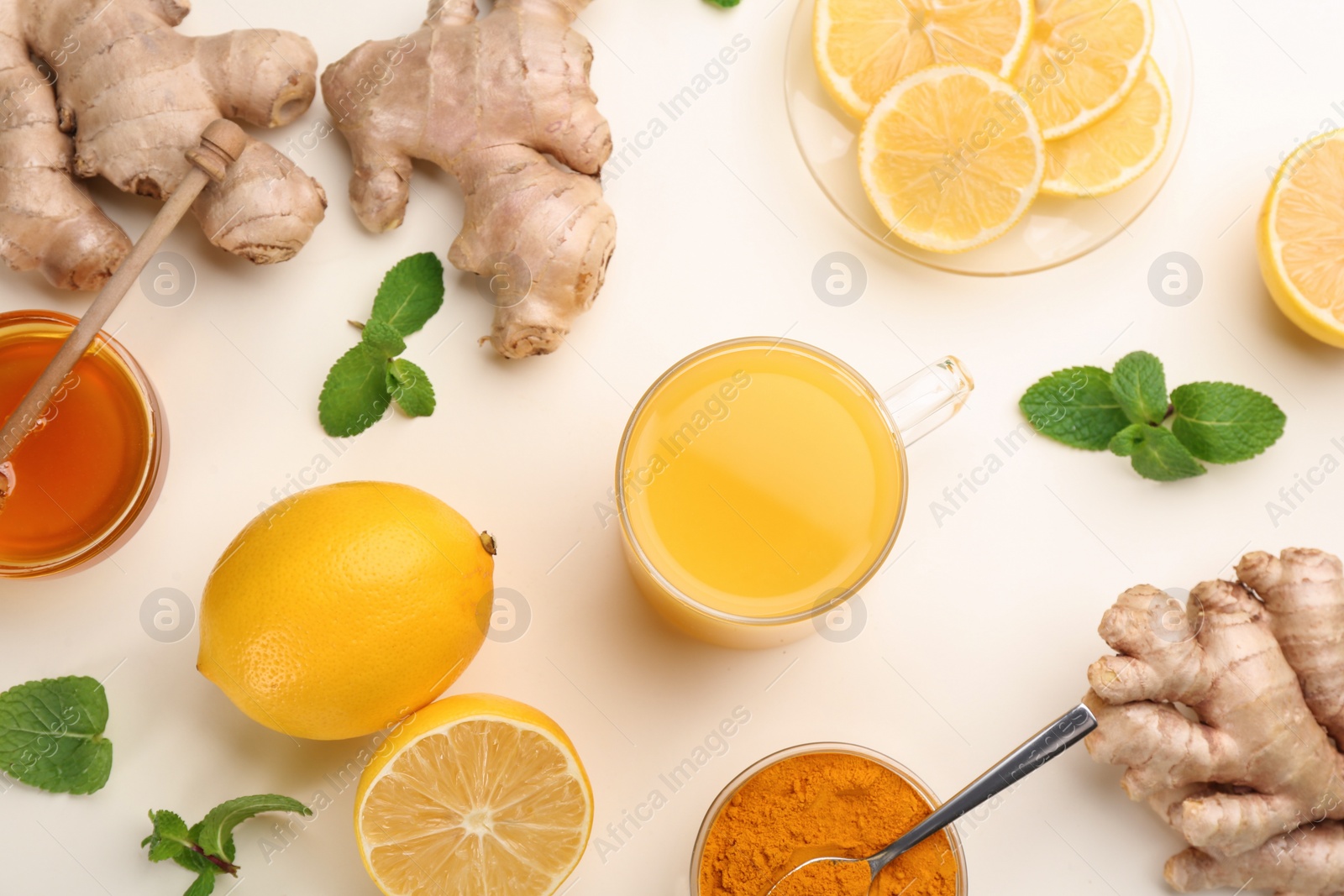 Photo of Immunity boosting drink and ingredients on white background, flat lay