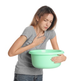 Woman with basin suffering from nausea on white background. Food poisoning