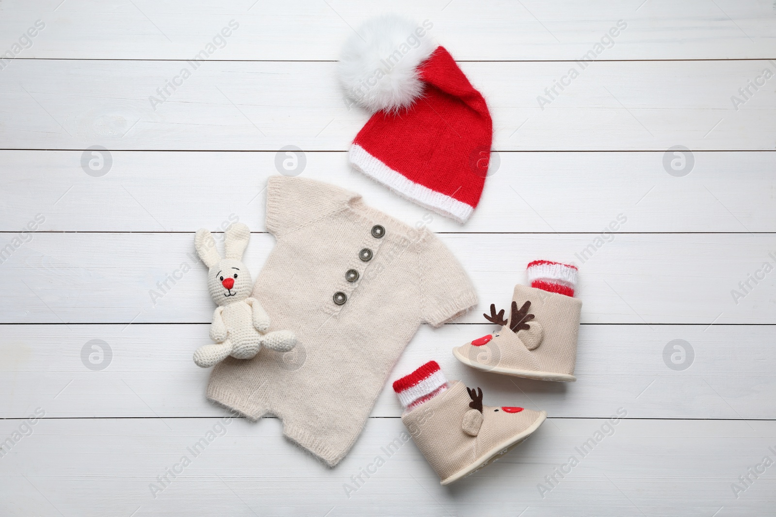 Photo of Flat lay composition with child's clothes on white wooden table