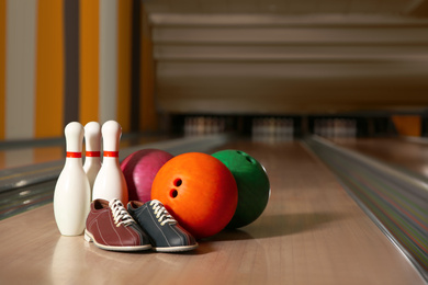 Photo of Shoes, pins and balls on bowling lane in club. Space for text