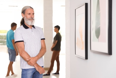 Photo of Senior man at exhibition in art gallery