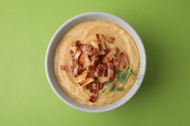 Photo of Delicious lentil soup with bacon and croutons on green background, top view