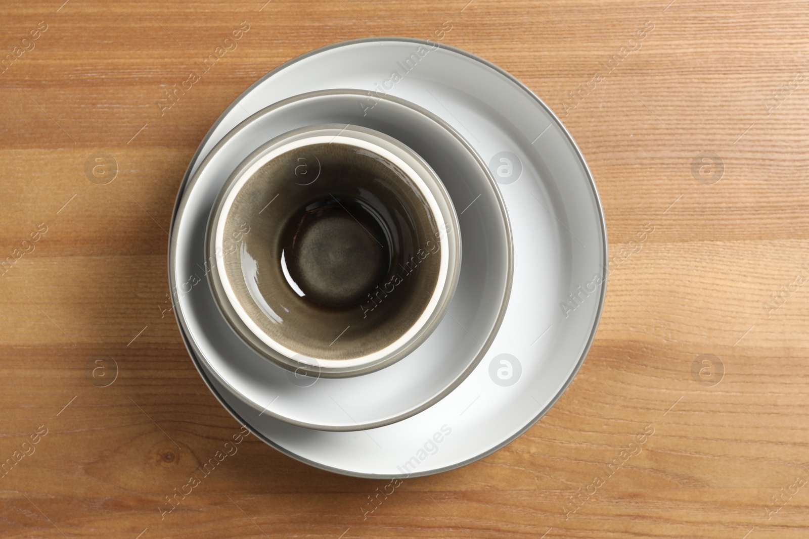 Photo of New empty dishes on wooden table, top view