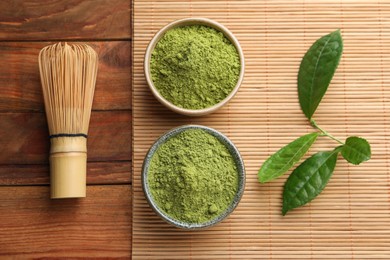 Green matcha powder and bamboo whisk on wooden table, flat lay