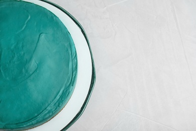 Photo of Delicious homemade spirulina cheesecake on light background, top view. Space for text