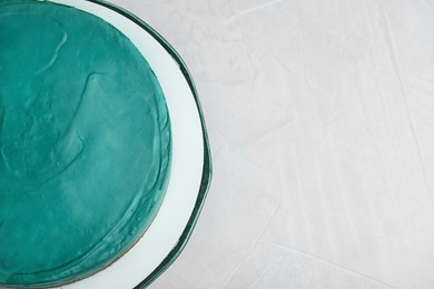 Delicious homemade spirulina cheesecake on light background, top view. Space for text