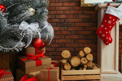 Photo of Decorated Christmas tree and gift boxes in festive room interior