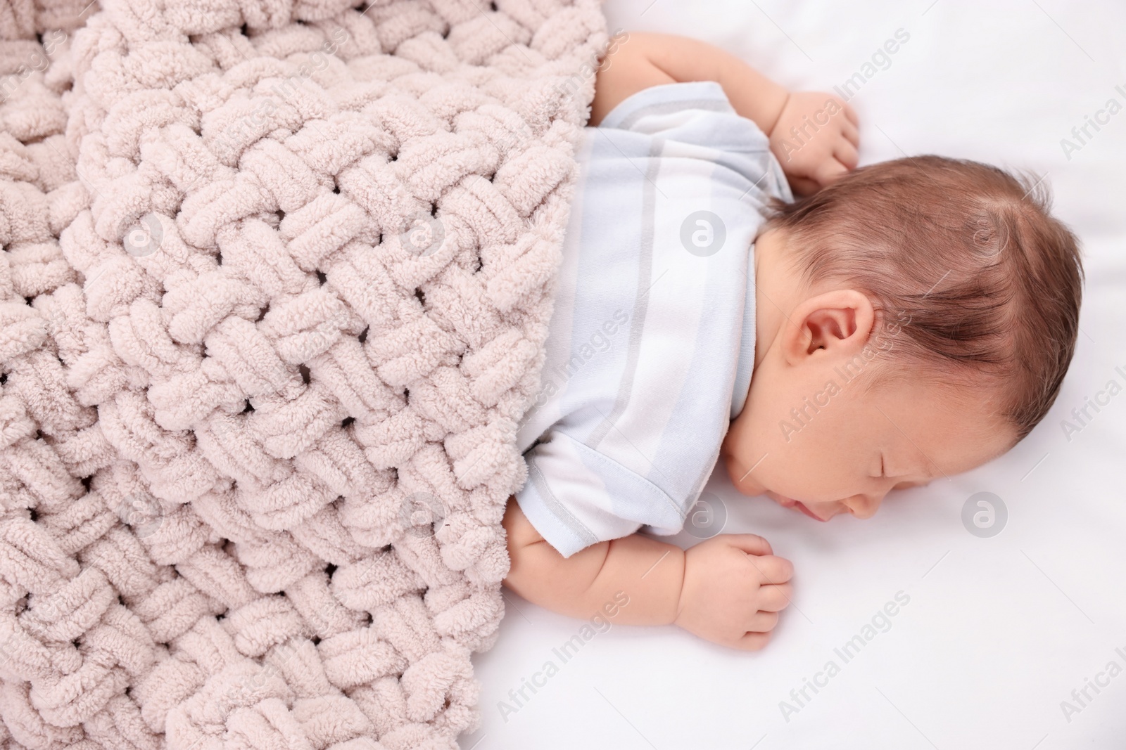 Photo of Cute newborn baby sleeping under beige soft blanket on bed