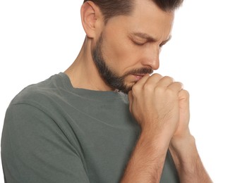 Photo of Man with clasped hands praying on white background, closeup