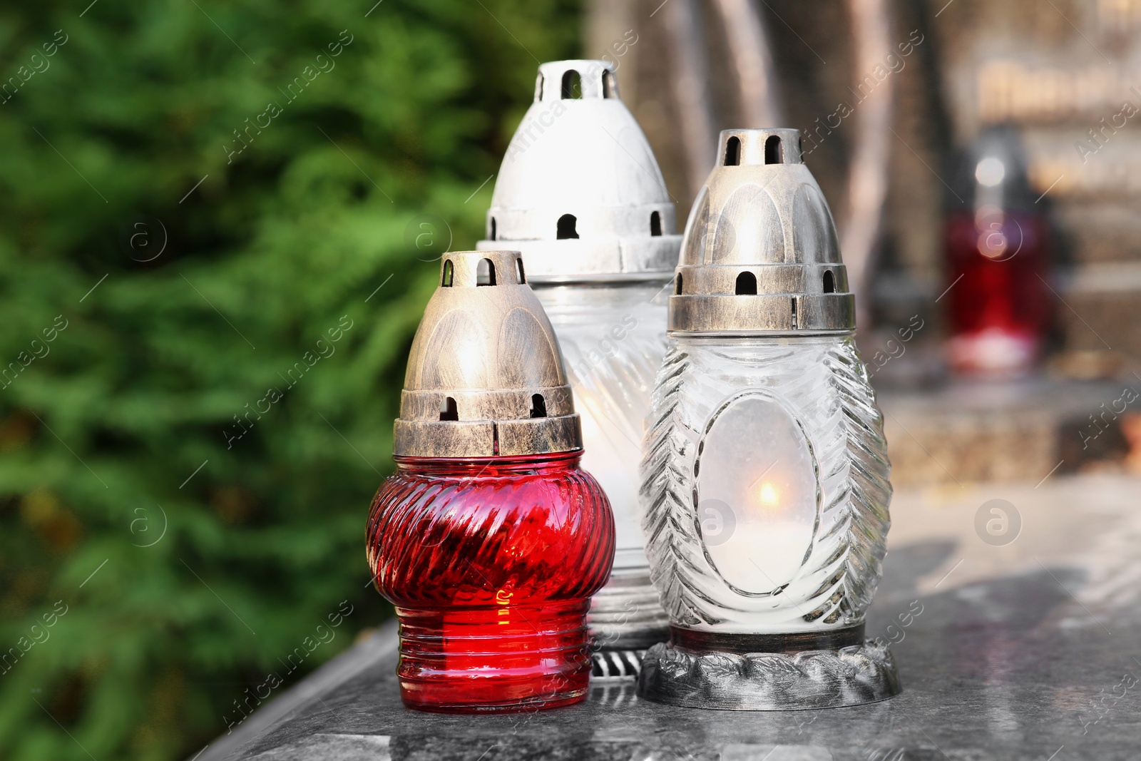 Photo of Grave lanterns on granite surface in cemetery