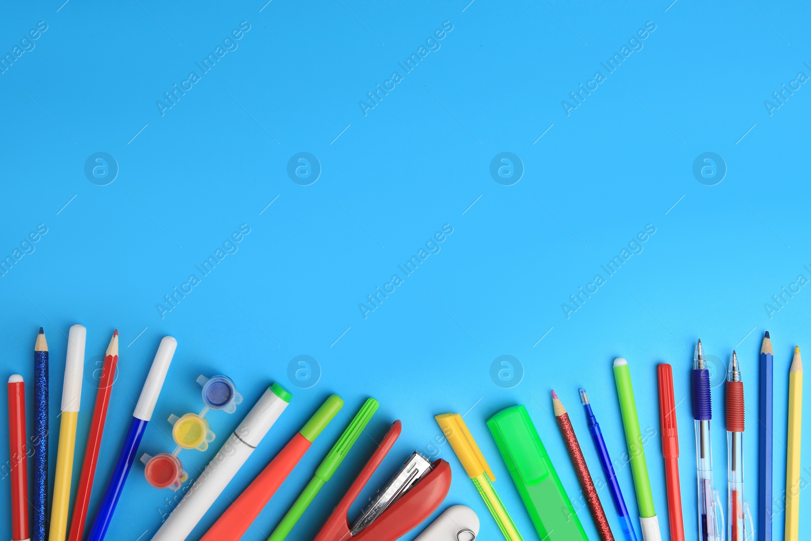 Photo of Flat lay composition with different school stationery on light blue background, space for text. Back to school