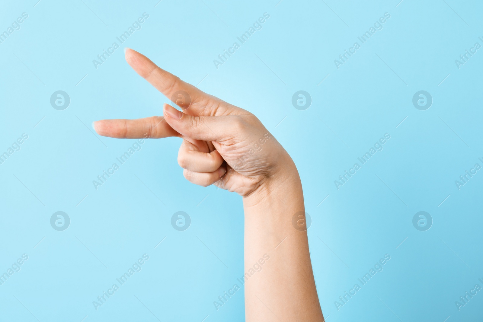 Photo of Woman showing P letter on color background, closeup. Sign language