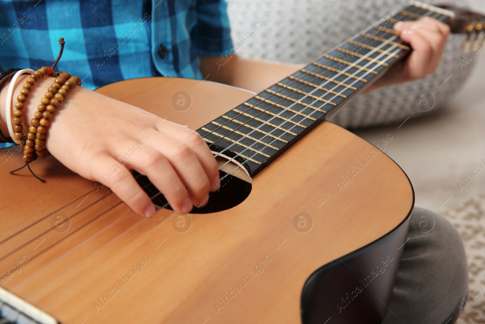 Photo of Little boy playing guitar on floor, closeup