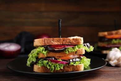 Photo of Delicious fresh eggplant sandwich served on wooden table