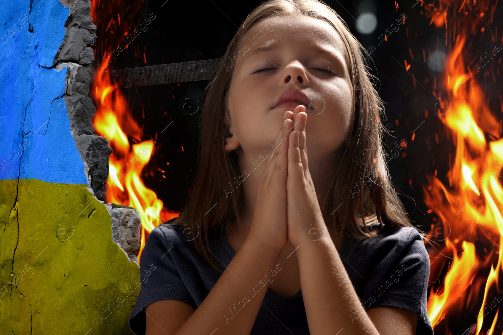 Image of Little girl praying and wall of ruined building painted in color of national flag on fire. Stop war in Ukraine