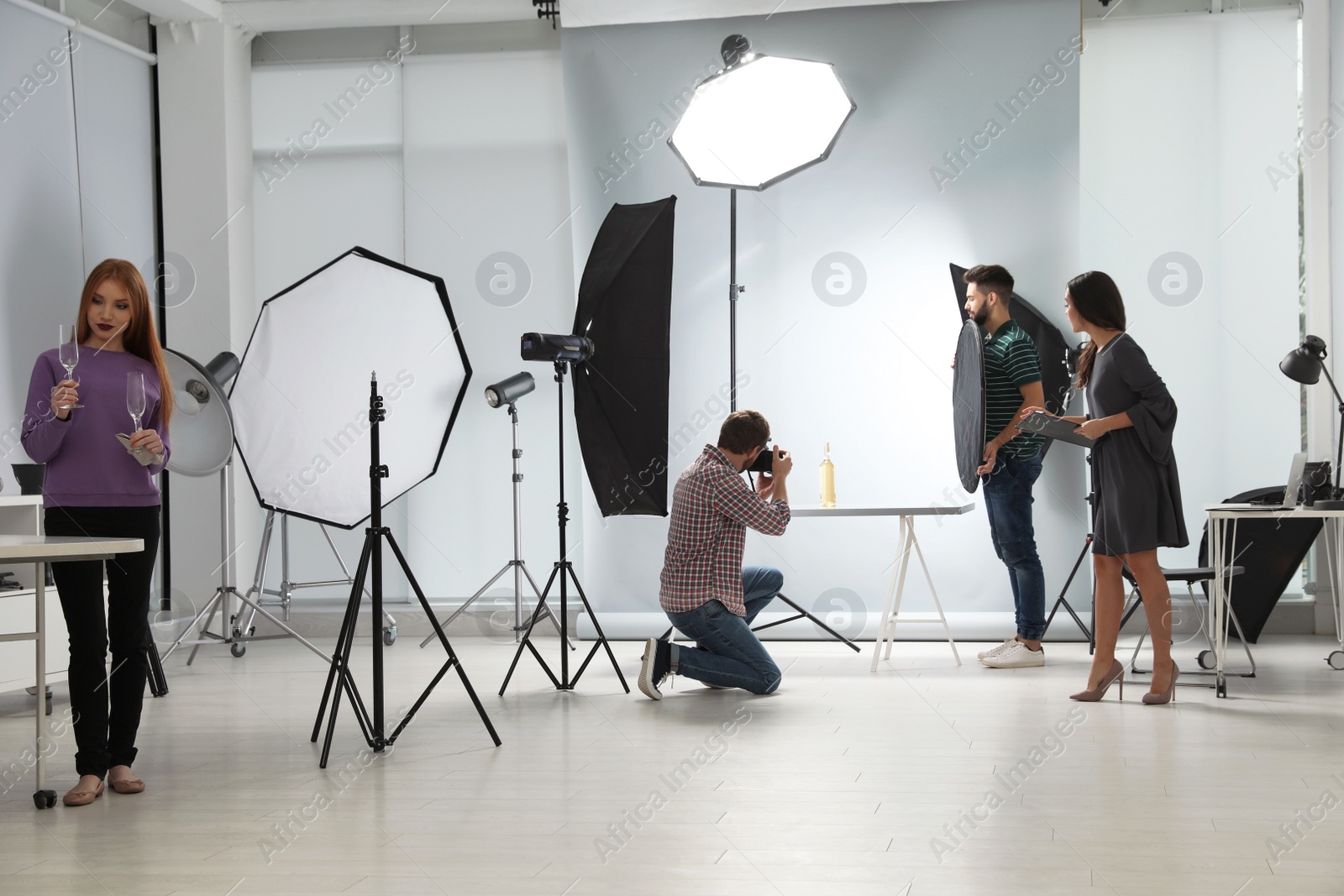 Photo of Photo studio with professional equipment and team of workers