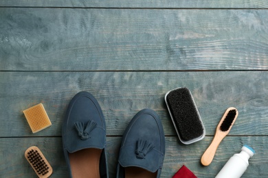 Photo of Stylish footwear with shoe care accessories on light blue wooden table, flat lay. Space for text
