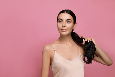 Photo of Young woman wearing elegant pearl earrings on pink background, space for text