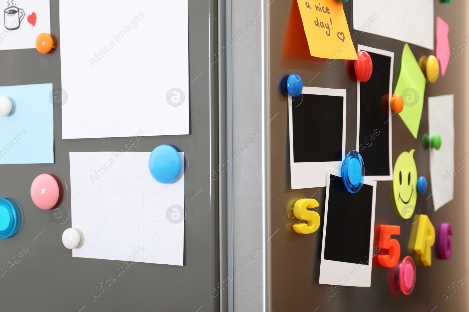 Photo of Sheets of paper and photos with colorful magnets on refrigerator. Space for text