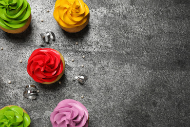 Flat lay composition with colorful birthday cupcakes on grey table. Space for text