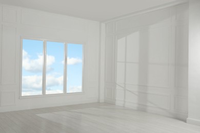 Empty room with white walls and large window