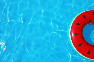 Photo of Inflatable ring floating in swimming pool on sunny day, top view with space for text