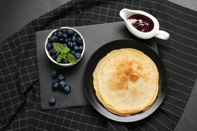 Delicious crepes with mint and blueberries on grey table, flat lay