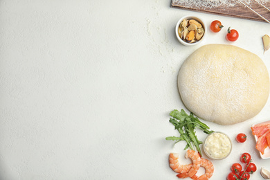 Photo of Flat lay composition with dough and fresh ingredients on white table, space for text. Pizza recipe