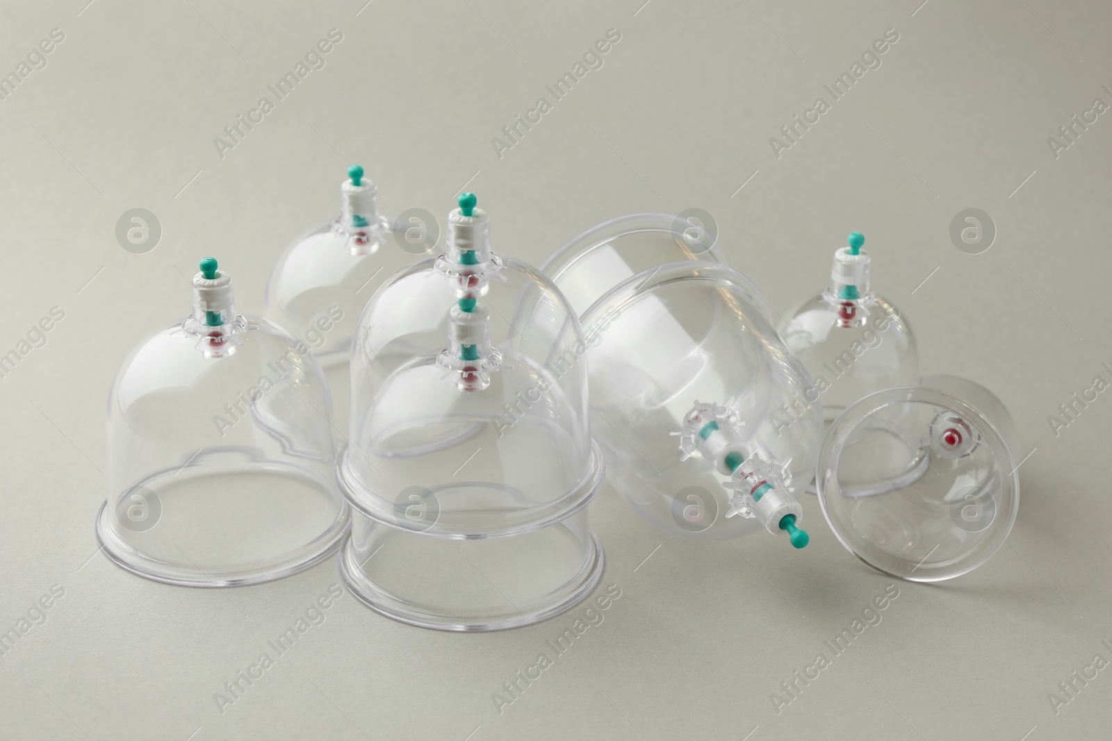 Photo of Plastic cups on light grey background. Cupping therapy