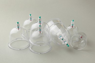 Photo of Plastic cups on light grey background. Cupping therapy