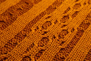 Beautiful orange knitted fabric as background, closeup
