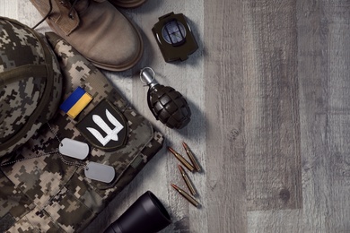 Photo of MYKOLAIV, UKRAINE - SEPTEMBER 19, 2020: Flat lay composition with Ukraine military outfit and equipment on floor, space for text