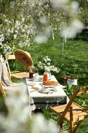 Beautiful table setting with spring flowers in garden on sunny day