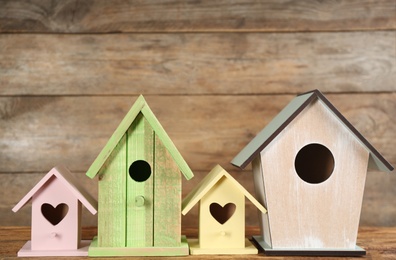 Photo of Beautiful colorful bird houses on wooden table