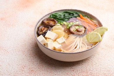 Bowl of vegetarian ramen on color textured table