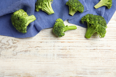 Photo of Fresh green broccoli on white wooden table, flat lay. Space for text
